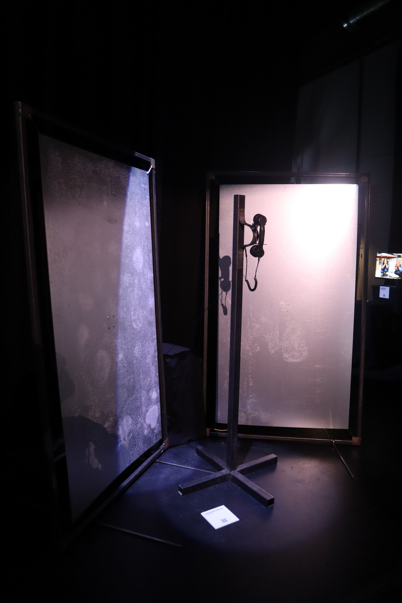 Phone on a metal pole with a red light ontop of it